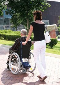 ORTOPEDIA RAFI Mujer llevando anciano en silla de ruedas